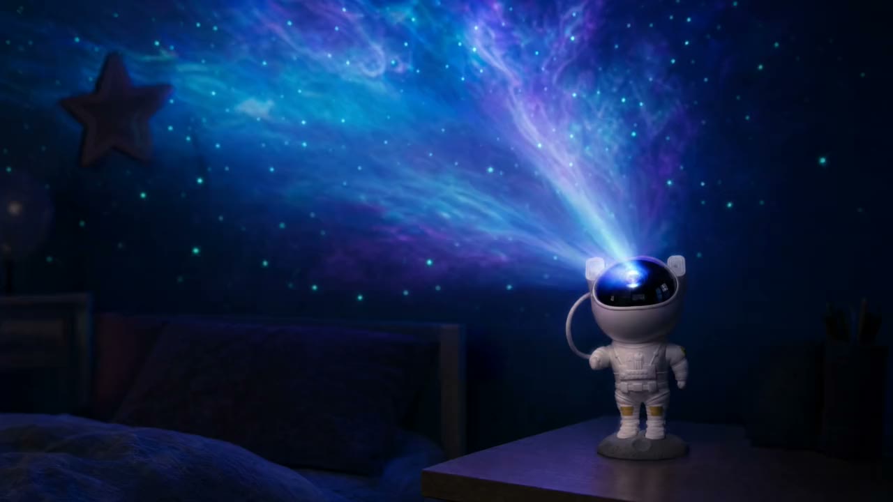 Karanlık bir odada tavana galaksi yansıtan astronot gece lambası